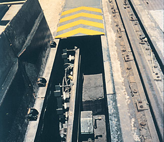 Detalle de carriles conductores de pie de acero y cabeza de cobre montados en canal con cubierta de chapa